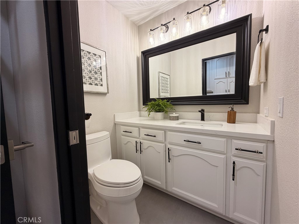 1677 South Hill Avenue Fallbrook, CA 92028 - Photo 27 of 74 a bathroom with a toilet sink vanity and mirror