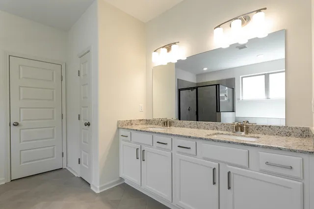 a bathroom with a granite countertop sink double and mirror