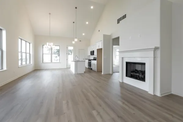 an empty room with wooden floor and a fireplace