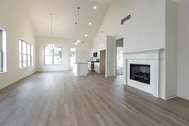an empty room with wooden floor and a fireplace