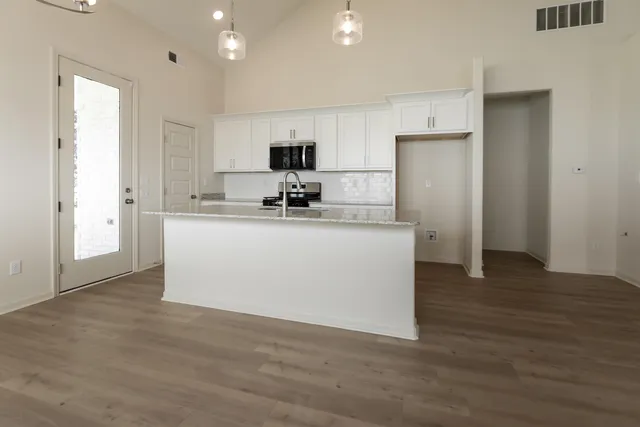 a kitchen with stainless steel appliances a sink a stove a refrigerator and cabinets