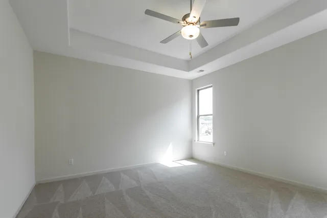 an empty room with a window and a fan
