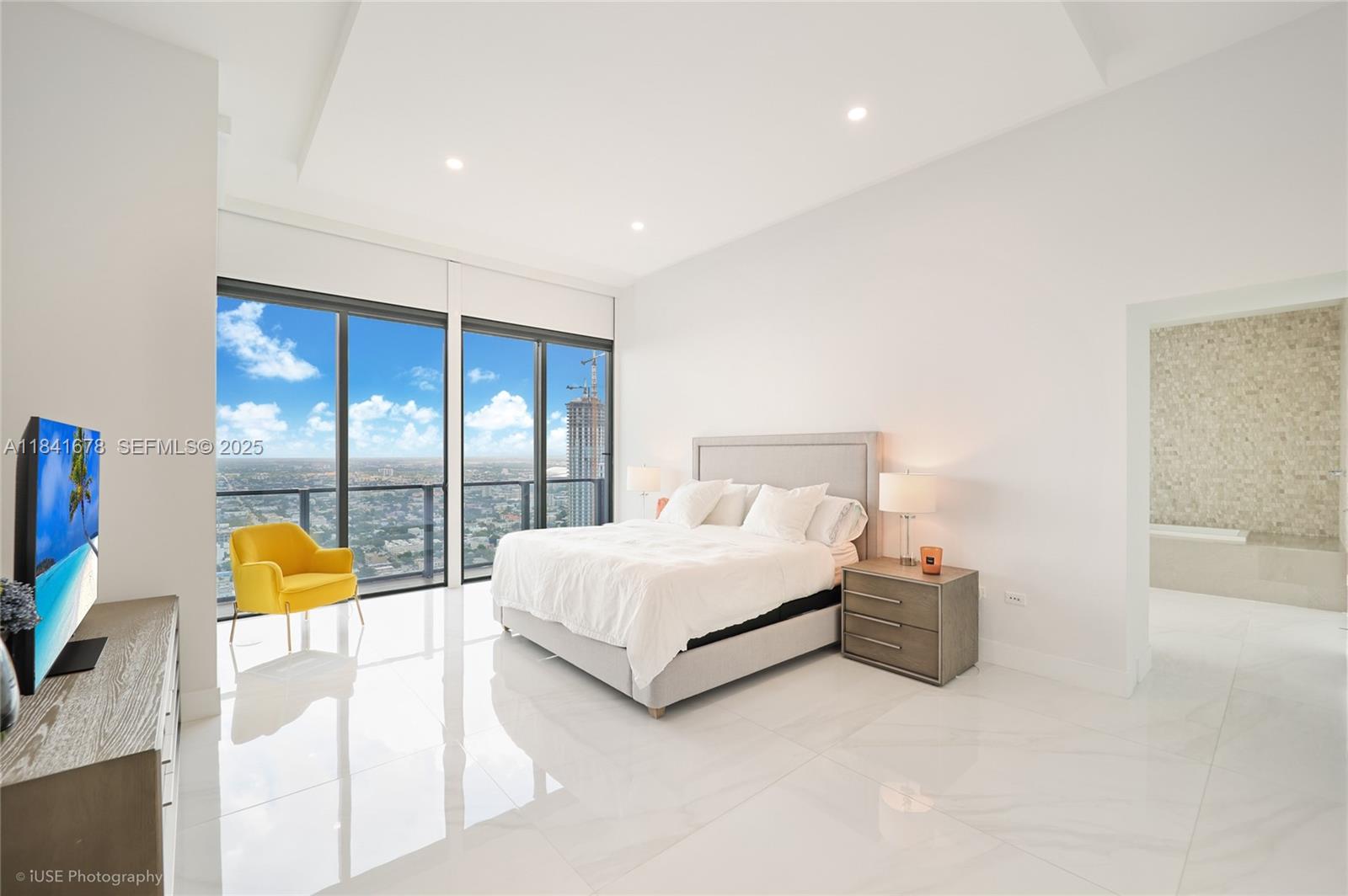 88 Southwest 7th Street, Unit 4101 Miami, FL 33130 - Photo 19 of 35 a spacious bedroom with a bed and a large window