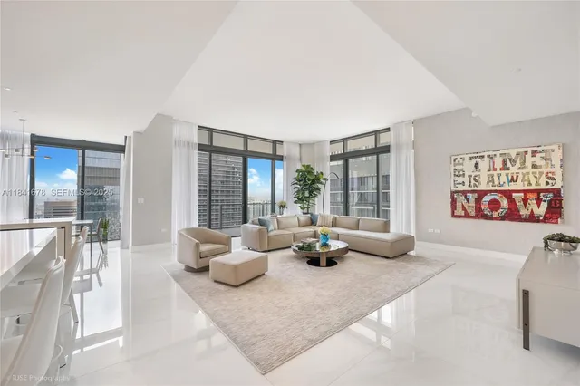 a living room with furniture and large windows