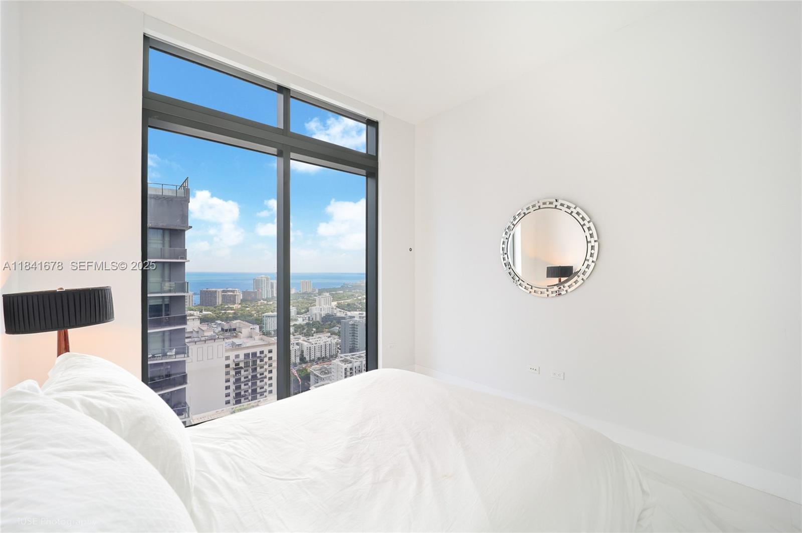 88 Southwest 7th Street, Unit 4101 Miami, FL 33130 - Photo 27 of 35 a bedroom with a large bed and a large window
