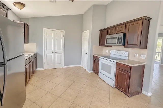 a kitchen with stainless steel appliances a stove microwave and refrigerator