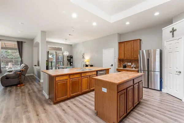 a large kitchen with stainless steel appliances granite countertop a large counter top and a wooden floors