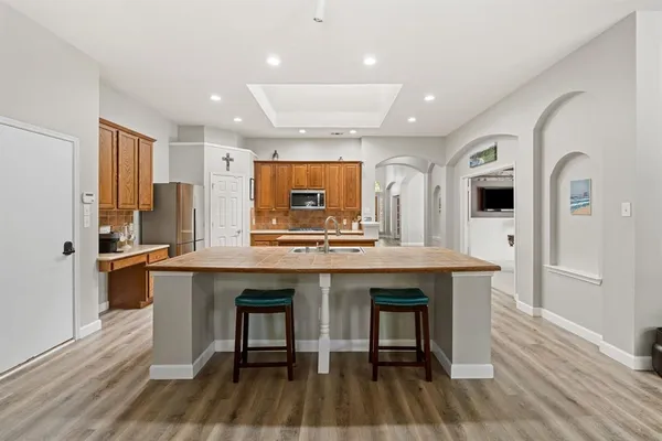 a kitchen with stainless steel appliances granite countertop a kitchen island a stove a refrigerator and a sink