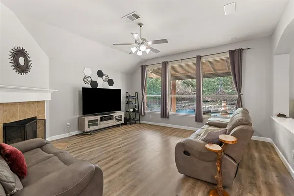 a living room with furniture a flat screen tv and a large window