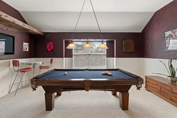 a living room with furniture pool table and window