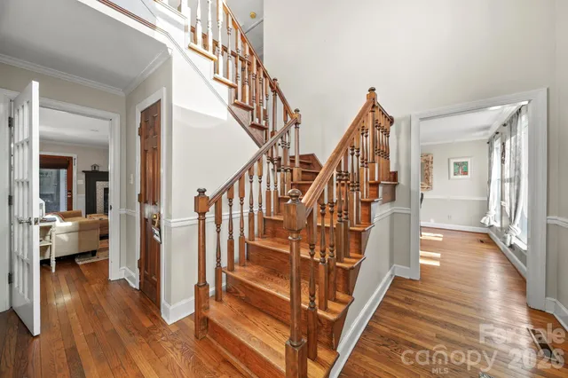 a view of staircase with lots of frames on wall and wooden floor