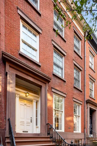 a view of a street with potted plants and a tree