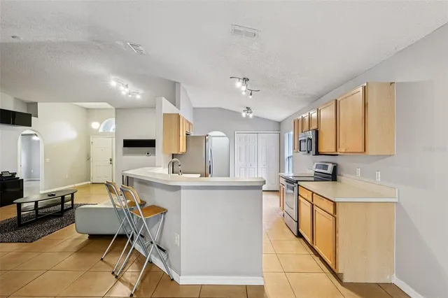 a kitchen with stainless steel appliances kitchen island granite countertop a sink and cabinets