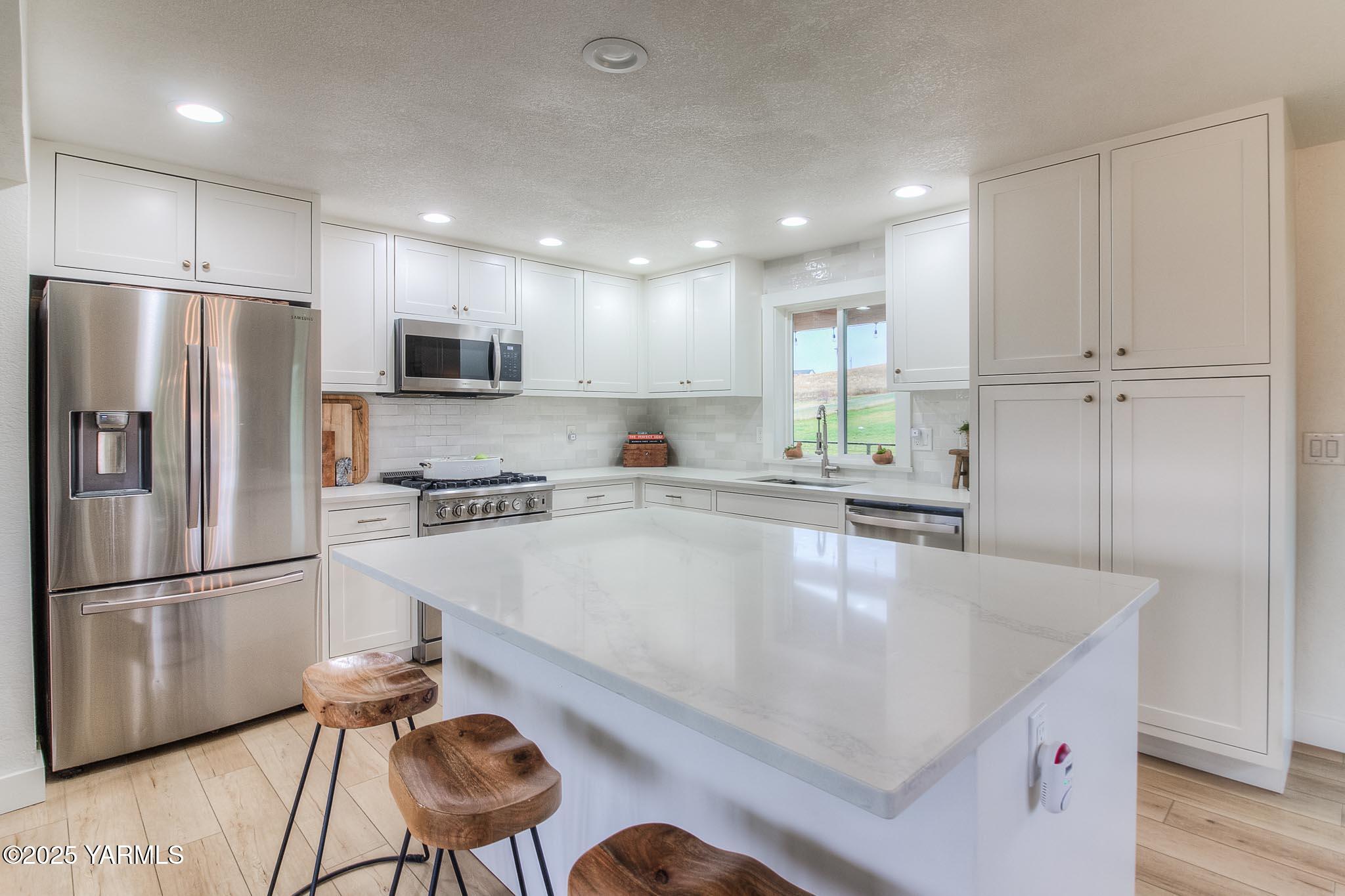 240 Knoll Road Yakima, WA 98908 - Photo 12 of 47 a large kitchen with a table chairs refrigerator and microwave
