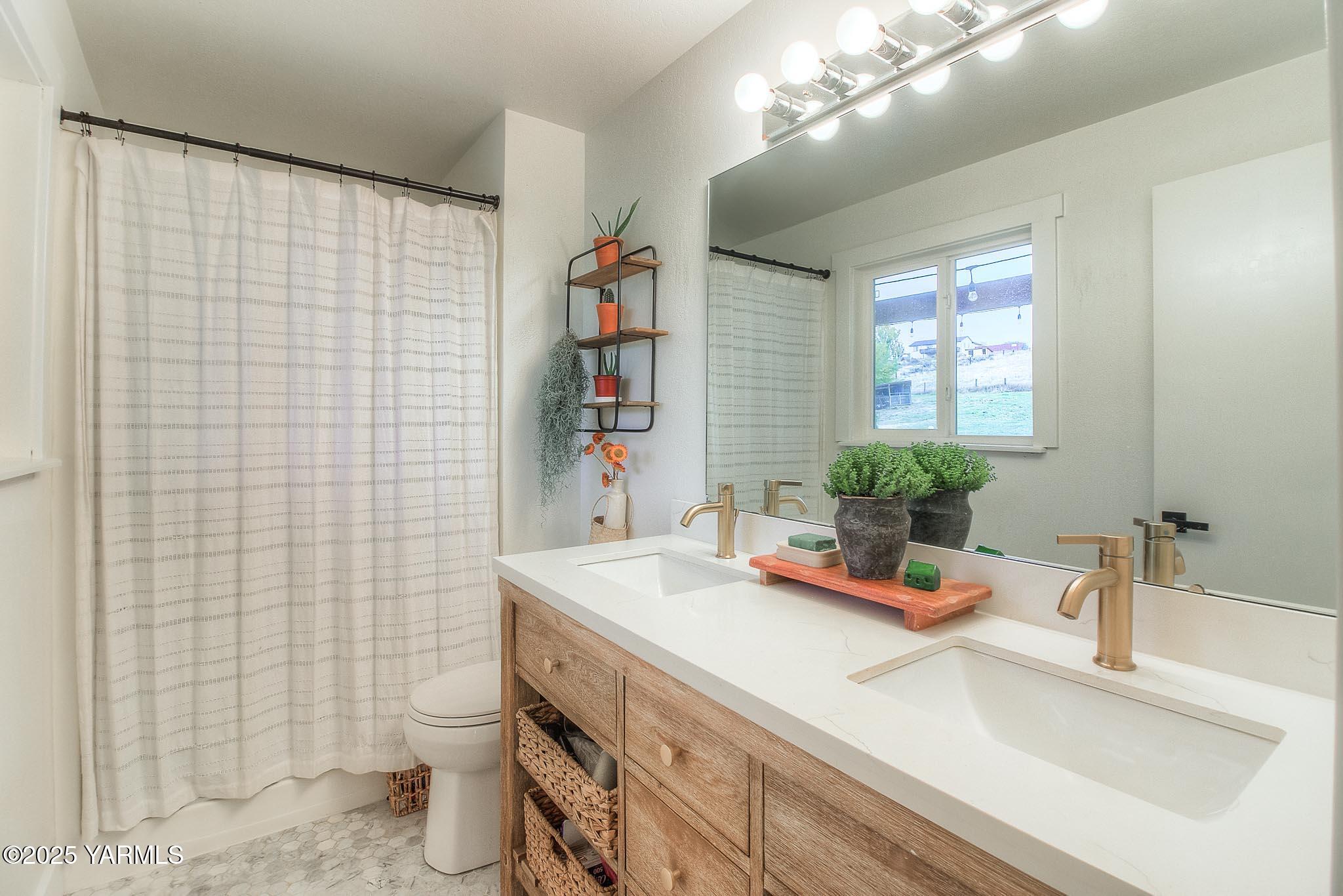 240 Knoll Road Yakima, WA 98908 - Photo 16 of 47 a bathroom with a sink a toilet and shower curtain