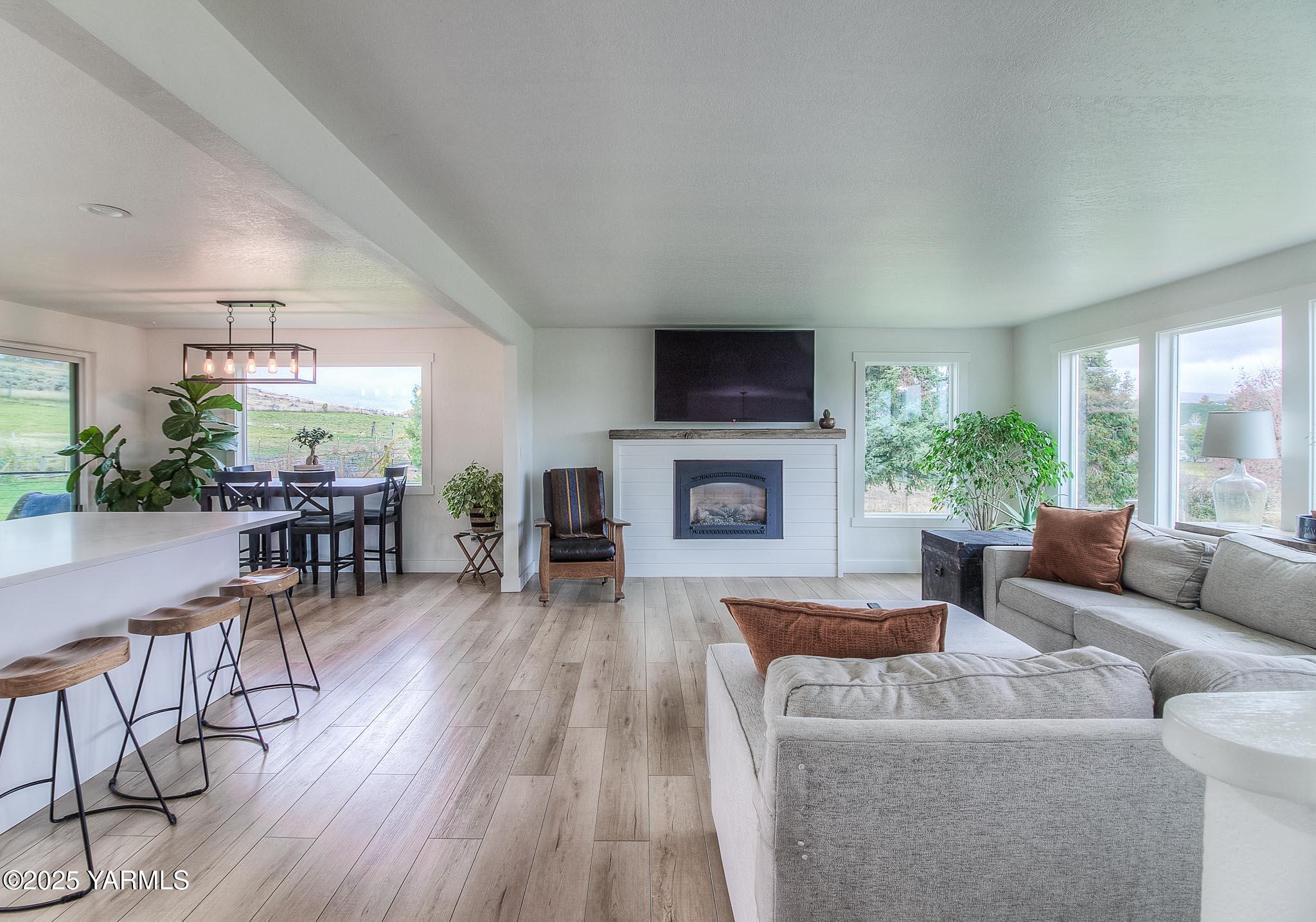 240 Knoll Road Yakima, WA 98908 - Photo 5 of 47 a living room with furniture a fireplace a flat screen tv and a large window
