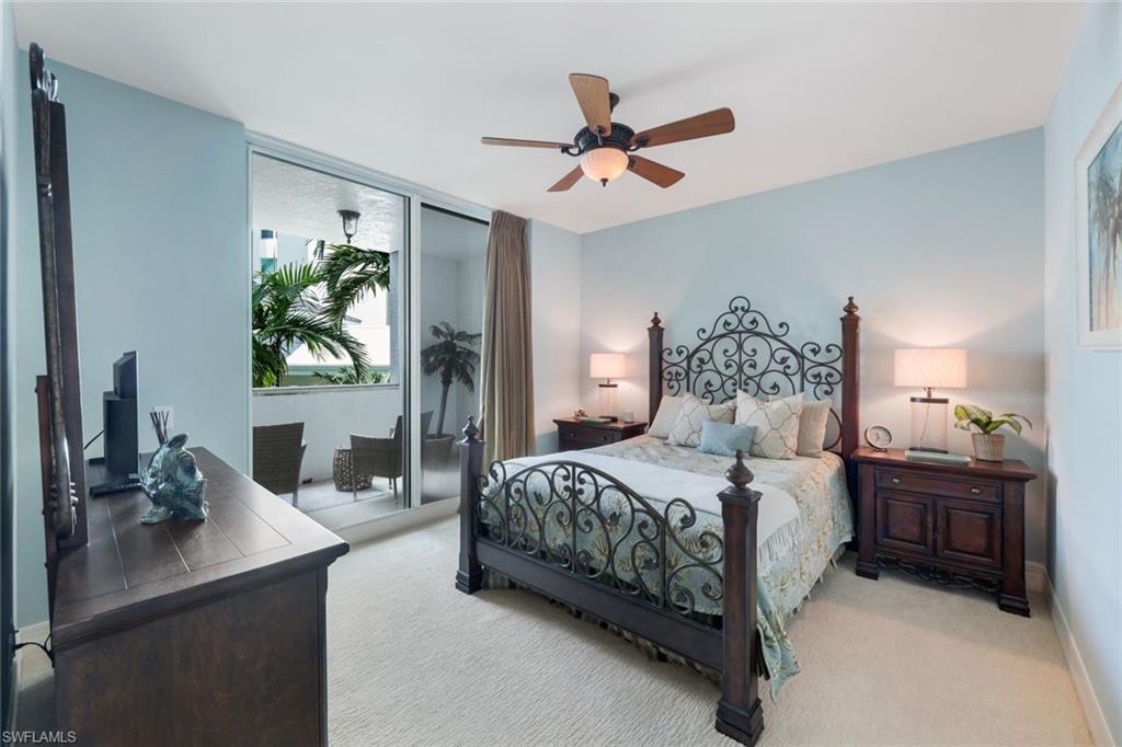 295 Grande Way, Unit T05 Naples, FL 34110 - Photo 23 of 49 a bedroom with a bed a ceiling fan and a dresser