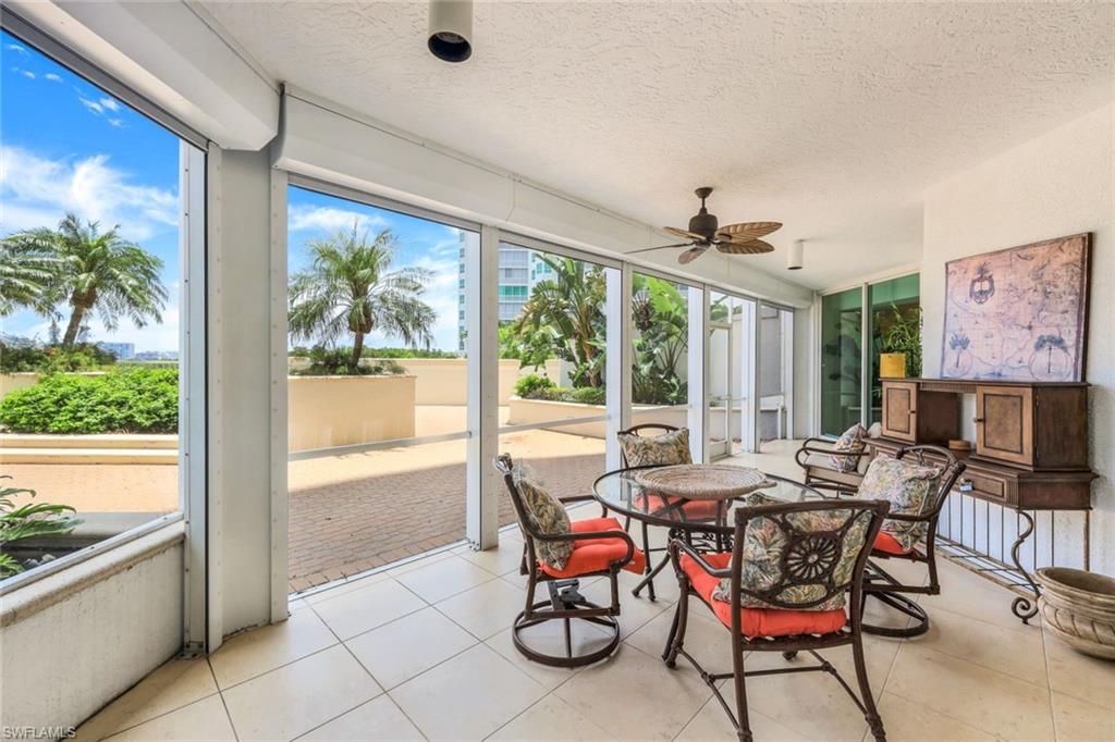 295 Grande Way, Unit T05 Naples, FL 34110 - Photo 26 of 49 a view of a dining room with furniture large windows and wooden floor