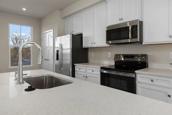 a kitchen with stainless steel appliances granite countertop a refrigerator stove top oven and sink
