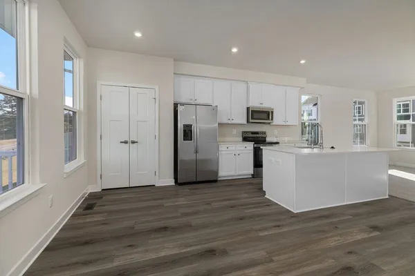 a view of a kitchen with wooden floor and electronic appliances