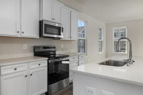 a kitchen with white cabinets and stainless steel appliances