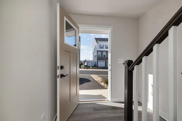 a view of a hallway with wooden floor and entryway