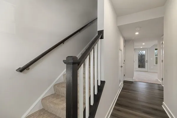 a view of a hallway with wooden floor and staircase