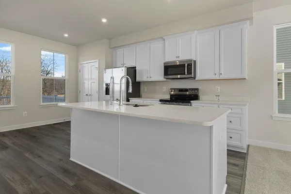 a kitchen with stainless steel appliances granite countertop a stove a sink a refrigerator a microwave and cabinets