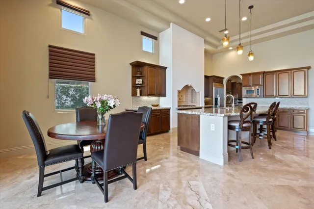 a kitchen with stainless steel appliances granite countertop sink stove and dining table