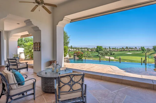 a living room with furniture a chandelier and a large window