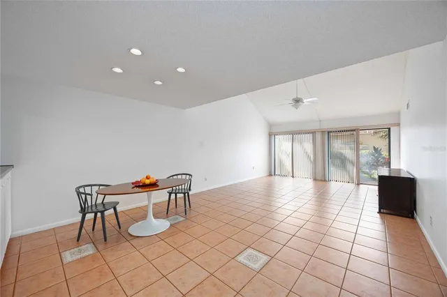 a view of an empty room with window and a kitchen