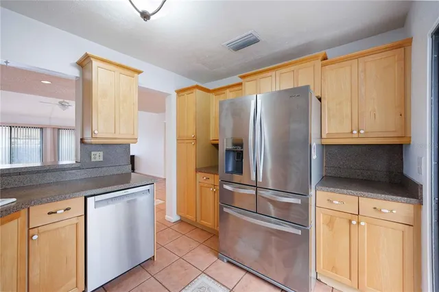 a kitchen with stainless steel appliances granite countertop a refrigerator and a stove top oven