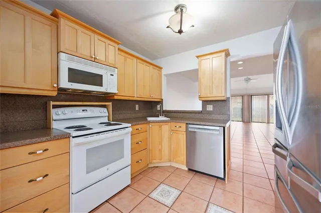 a kitchen with stainless steel appliances granite countertop a stove a sink and a refrigerator