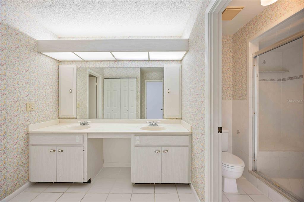 2767 Horseshoe Court, Unit Q3 Sarasota, FL 34235 - Photo 24 of 49 a spacious bathroom with a double vanity sink a toilet and a mirror