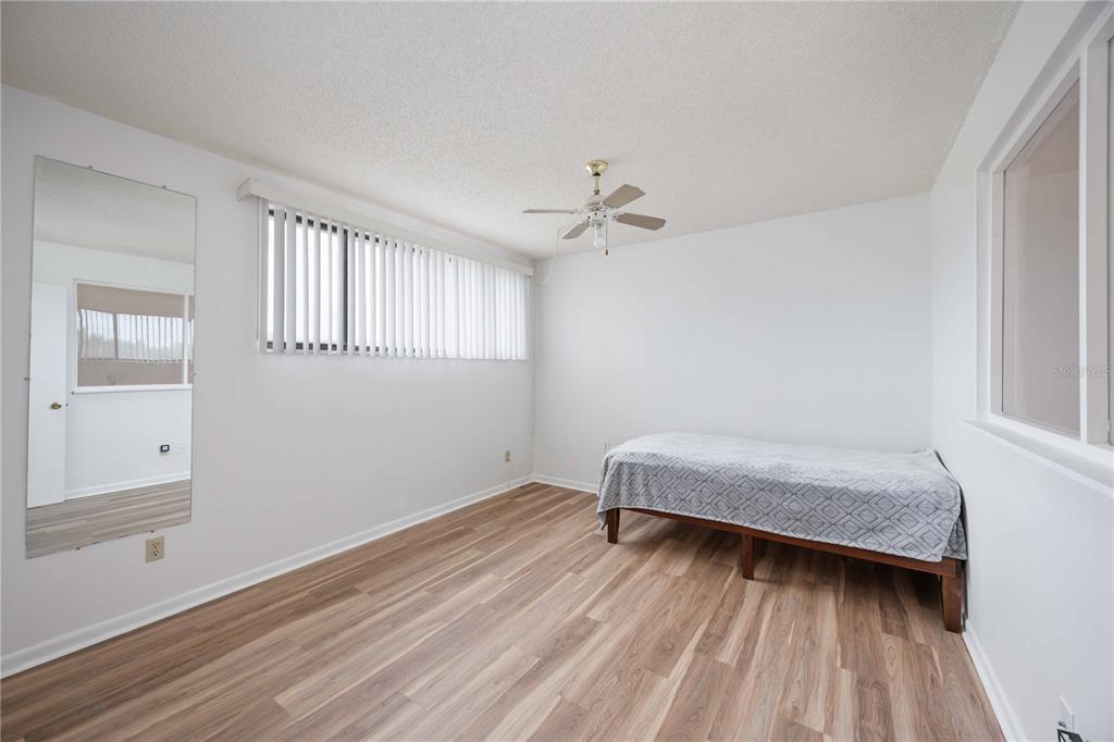 2767 Horseshoe Court, Unit Q3 Sarasota, FL 34235 - Photo 27 of 49 a room with a bed and wooden floor