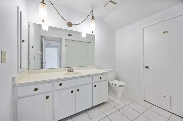 a bathroom with a double vanity sink a toilet and a mirror