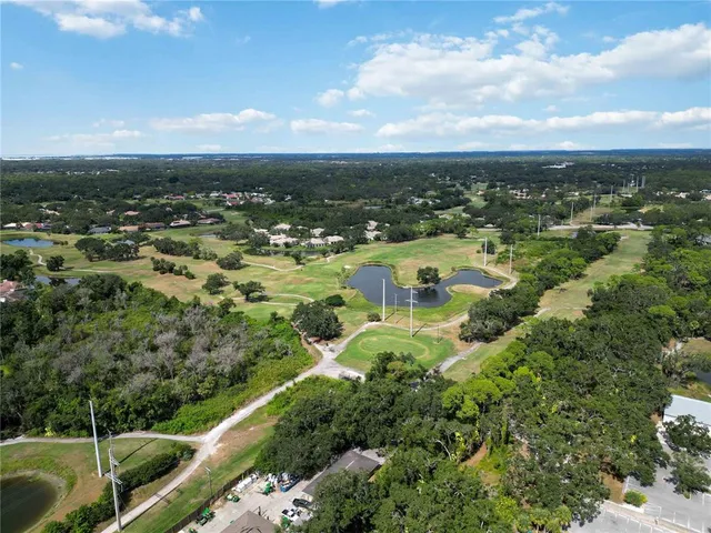 an aerial view of residential houses with outdoor space and trees
