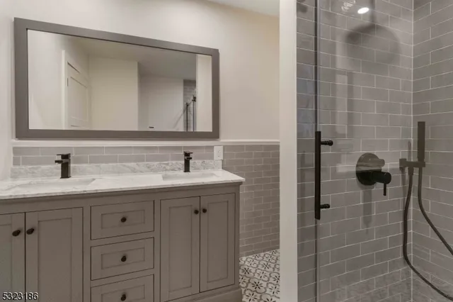 a bathroom with a granite countertop sink a mirror and a shower