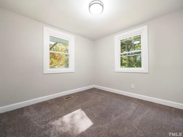 an empty room with a window and wooden floor