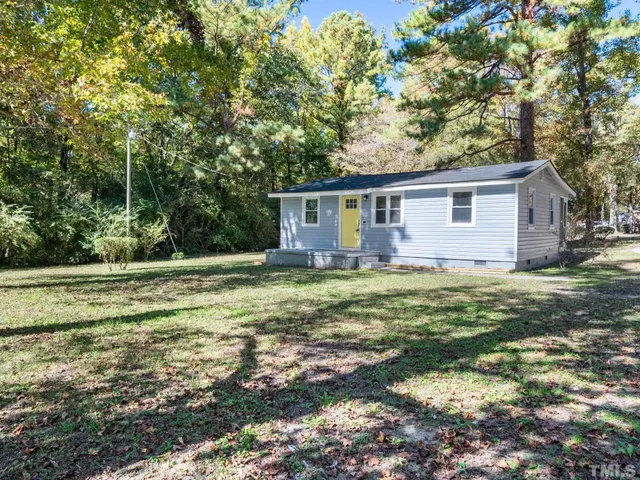 a front view of house with yard and trees