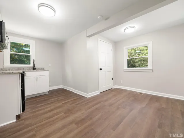 an empty room with a window and wooden floor
