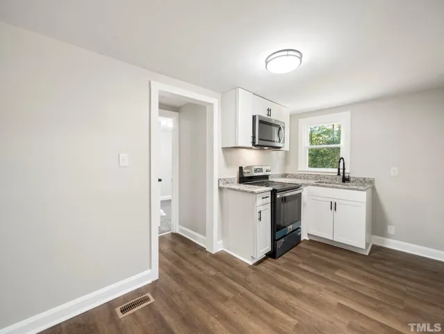 a kitchen with sink a microwave and cabinets
