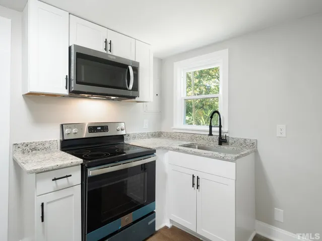 a kitchen with granite countertop a stove and a sink