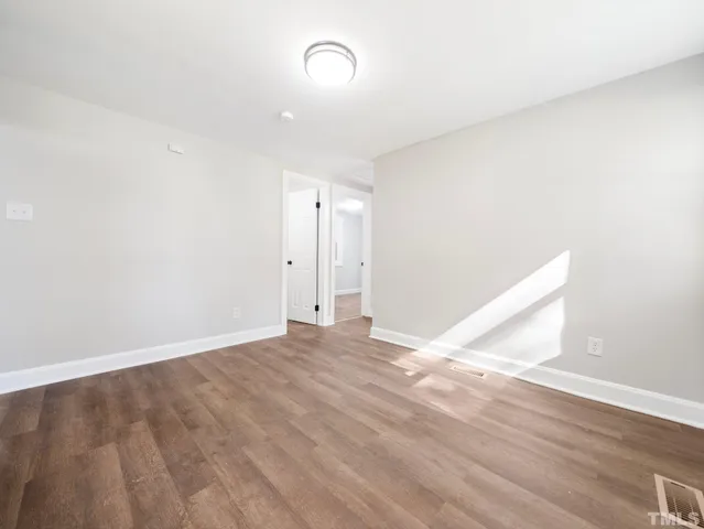a view of an empty room with wooden floor