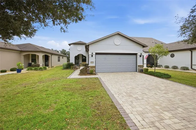 a front view of a house with a yard and trees