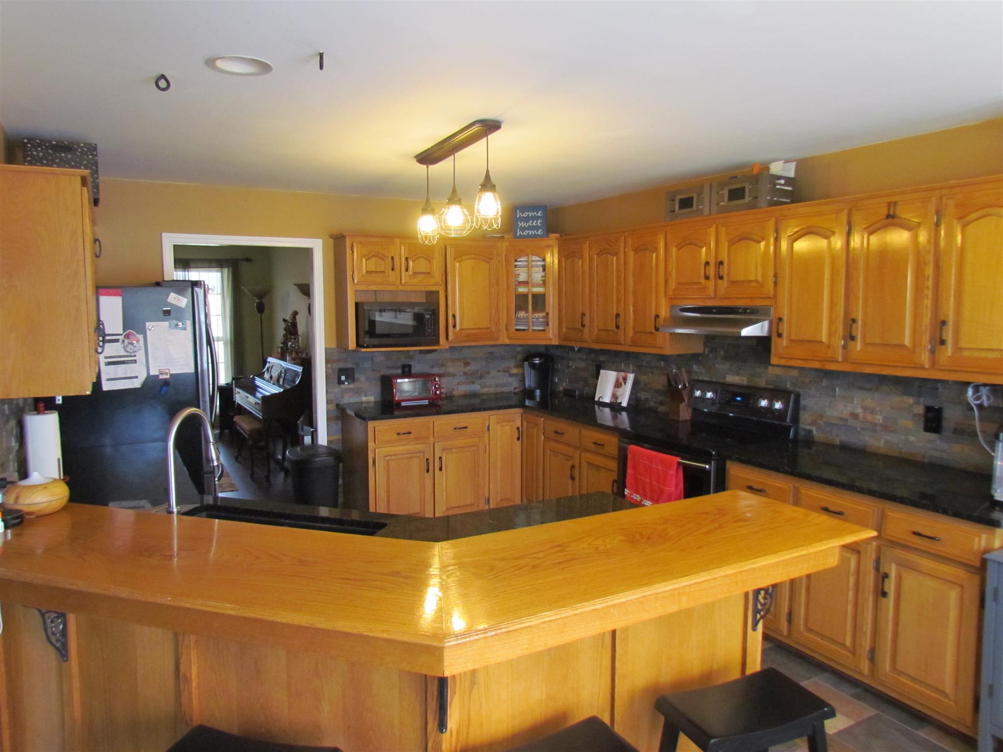 187 Coleman Road Readyville, TN 37149 - Photo 4 of 30 The kitchen has granite countertops, custom tile backsplash, smooth top stove, single oven, dishwasher, and a pantry