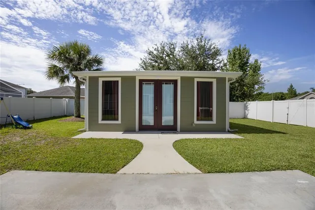 a view of a house with backyard and sitting area