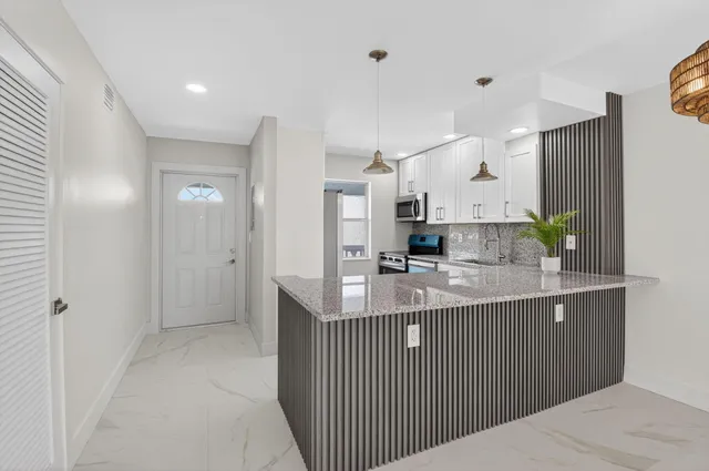 an empty room with windows and ceiling fan