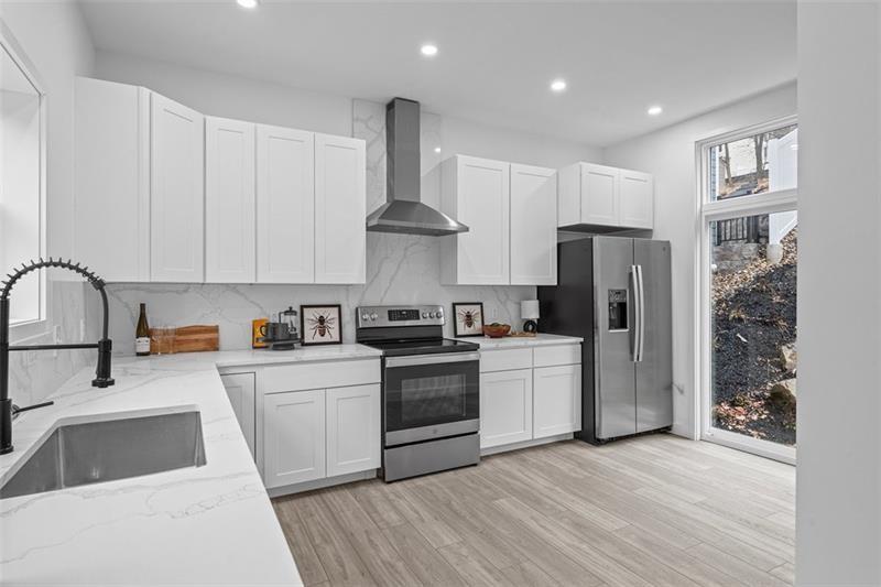 431 Shaler Street Pittsburgh, PA 15211 - Photo 7 of 33 a kitchen with white cabinets and stainless steel appliances