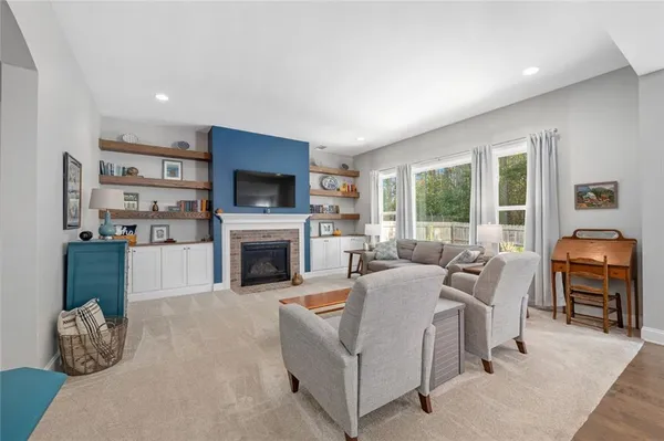a living room with furniture a fireplace and a flat screen tv